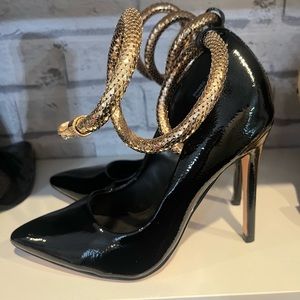 Black patent leather pumps with gold snake ankle chain